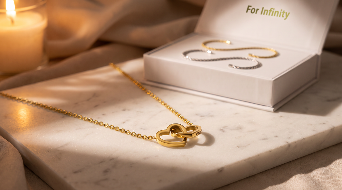 Engraved double heart necklace and permanent bracelet kit on white marble in warm light