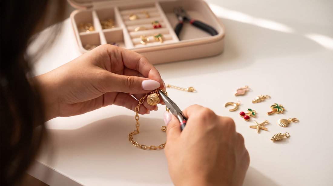Charm bracelet kit with over 100 charms, chains, and connectors displayed on a warm white flat-lay surface