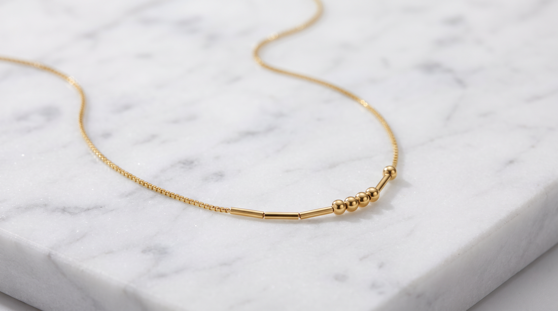 Personalized Morse Code Necklace in gold displayed on dark slate