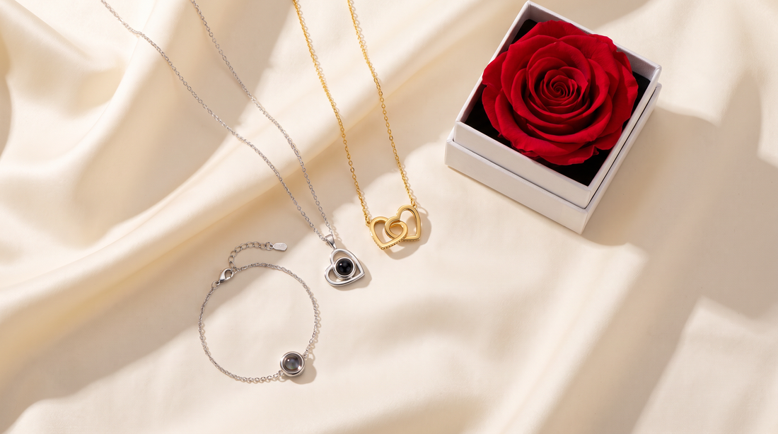 Heart pendant necklace, chain bracelet, and double heart necklace beside a rose gift box