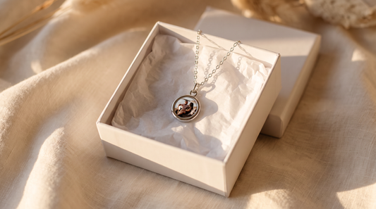 Open gift box with Circle Necklace with Picture Inside on white marble in soft morning light