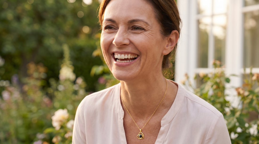Smiling woman wearing a gold heart pendant necklace
