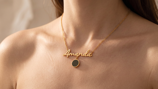 Gold Name Necklace with Photo Charm worn on a woman's neckline, featuring the cursive gold name plate and round pendant charm from Dazzle Wears