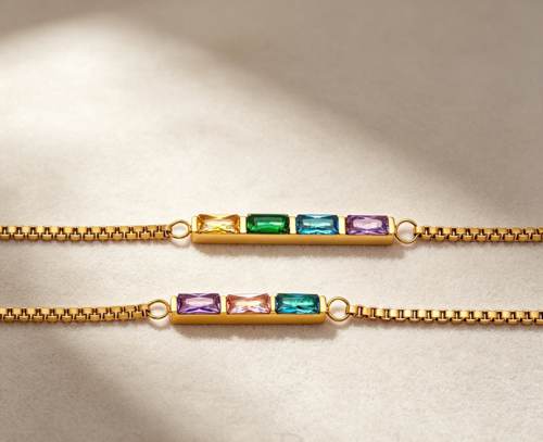 Two personalized dainty birthstone bracelets, three stone and four stone flat lay