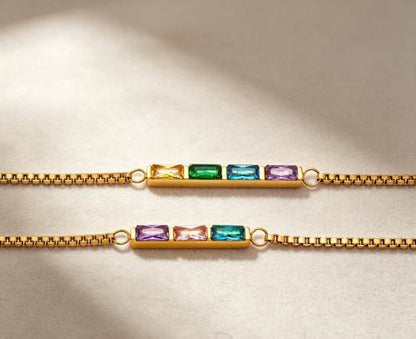 Two personalized dainty birthstone bracelets, three stone and four stone flat lay