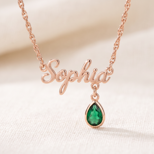 Rose gold personalized name necklace with emerald birthstone charm close up